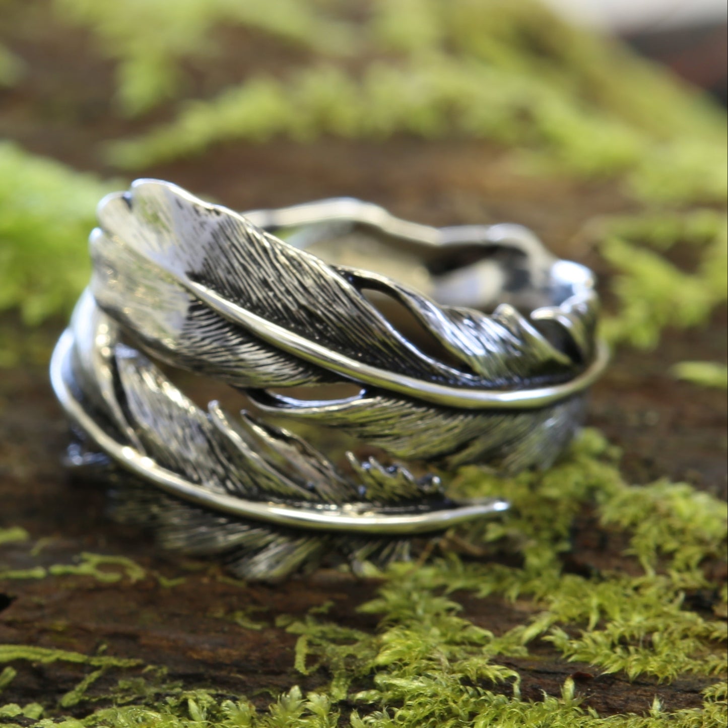 Silver Huia Feather Ring on a mossy surface